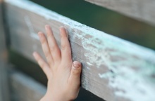 Χεράκι παιδιού σε ξύλινο φράκτη