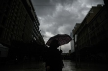 Άτομα κρατά ομπρέλα για να προστατευτεί από την κακοκαιρία - Σκοτεινός καιρός εν μέσω καταιγίδας