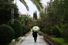 Γυναίκα με ομπρέλα περπατά στη βροχή