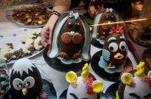 Χέρι υπαλλήλου τοποθετεί σε πάγκο πασχαλινά αυγά