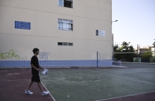 Μαθητής σε προαύλιο σχολείου με κάποια έγγραφα ανά χείρας