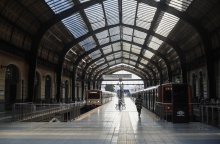 Συρμοί του ηλεκτρικού στον σταθμό του Πειραιά και μία γυναίκα που περπατά στην αποβάθρα