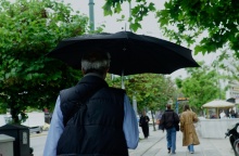 Άνδρας με ομπρέλα περπατά υπό βροχή