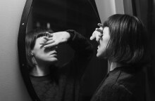 Γυναίκα καλύπτει τα μάτια της μπροστά σε καθρέφτη