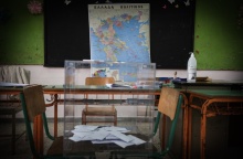 Κάλπη στερεωμένη σε δύο καρέκλες μπροστά από τον χάρτη της Ελλάδας