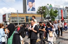 Πολίτες περπατούν μπροστά από αφίσα του Ρετζέπ Ταγίπ Ερντογάν - Σήμερα οι δεύτερες εκλογές στην Τουρκία