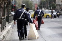 Τροχονόμοι διευθύνουν την κυκλοφορία των οχημάτων σε λεωφόρο και μεταφέρουν εμπόδια για το κλείσιμο δρόμου