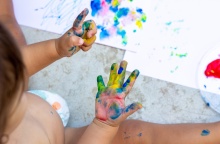 Παιδί ζωγραφίζει έχοντας λερώσει τα χεράκια του