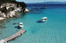 Παραλία των Παξών και μώλος όπου έχουν δέσει δύο καραβάκια