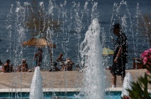 Άτομα σε παραλία διακρίνονται πίσω από σιντριβάνι στην περιοχή του Παλαιού Φαλήρου