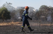 Πυροσβέστης σε σημείο όπου έχει πάρει φωτιά