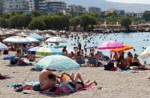 Λουόμενοι σε παραλία απολαμβάνουν ήλιο και θάλασσα