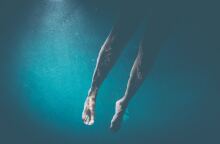 Τα πόδια ατόμου στη θάλασσα 