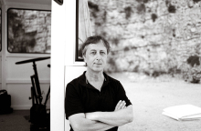 Ο Γάλλος σκηνοθέτης Φιλίπ Κεν με φόντο το σκηνικό της παράστασης "Ο κήπος των ηδονών" στην Αβινιόν