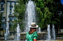 Γυναίκα με καπέλο μπροστά από το σιντριβάνι στην πλατεία Συντάγματος