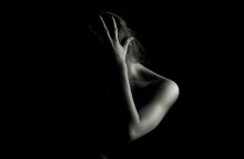 Γυναίκα με κρυμμένο το πρόσωπό της και το χέρι της στο κεφάλι σε ασπρόμαυρη φωτογραφία