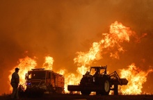 Φωτιά στην Πορτογαλία και οι σκιές ατόμου και οχημάτων με φόντο τις φλόγες