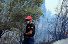 Πυροσβέστης με μάσκα και τη μάνικα ανά χείρας