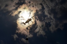 Πυροσβεστικό ελικόπτερο σε λήψη από κάτω με φόντο τα σύννεφα