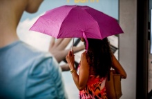 Γυναίκα κρατά ομπρέλα για να προστατευτεί από τη βροχή