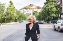 Η Πόπη Διαμαντάκου φωτογραφισμένη στη μέση του δρόμου με φόντο τον λόφο του Λυκαβηττού