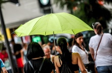 Γυναίκα με ομπρέλα προστατεύεται από τη βροχή