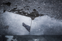 Αντανάκλαση της σημαίας στην Βουλή σε νερά βροχής