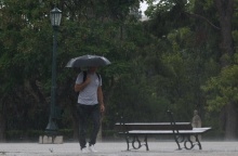 Νεαρός περπατά εν μέσω καταιγίδας κρατώντας ομπρέλα 