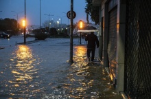 Άνδρας περπατά σε πλημμυρισμένο δρόμο στον Βόλο
