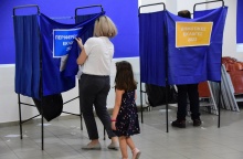 Κοριτσάκι μαζί με τη μητέρα του μπαίνει σε παραβάν για να ψηφίσει στις Δημοτικές και Περιφερειακές Εκλογές 2023