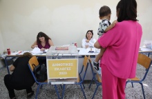 Γυναίκα κρατά το παιδί της στην αγκαλιά και προσέρχεται στην κάλπη για τις Αυτοδιοικητικές Εκλογές 2023