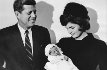 Η Τζον Φ. Κένεντι και η σύζυγός του Τζάκι, φωτογραφίζονται κρατώντας το νεογέννητο μωρό τους