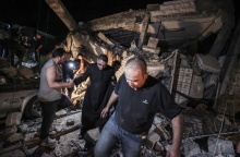 Ιερέας και πολίτες κοντά στο σημείο του βομβαρδισμού της ελληνορθόδοξης εκκλησίας στη Γάζα