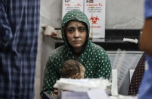 Μητέρα με την απόγνωση ζωγραφισμένη στο πρόσωπό της κοιτά τον φακό και κρατά στην αγκαλιά της το μωρό της μέσα στο νοσοκομείο Αλ Σίφα στη Γάζα