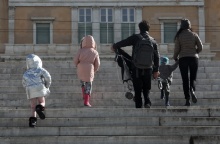 Πολίτες με παιδιά και με χοντρά ρούχα και σκουφιά για το κρύο ανεβαίνουν τα σκαλιά στην πλατεία Συντάγματος