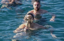 Νεαρός κρατά τον Σταυρό που μόλις έχει πιάσει από τα παγωμένα νερά της θάλασσας