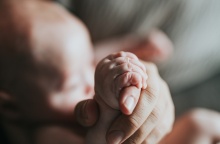 Χεράκι ατόμου κρατά το χεράκι μωρού