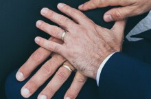 Χέρια δύο ανδρών που φορούν βέρες - Εικόνα που παραπέμπει σε γάμο