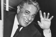 Ο Αριστοτέλης Ωνάσης με πλατύ χαμόγελο, υψώνει το χέρι του για να χαιρετίσει