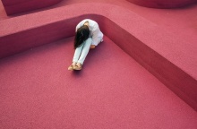 Κορίτσι που κλαίει καθισμένη, πιάνοντας τα γόνατά της