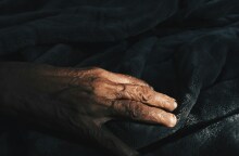 Χέρι ηλικιωμένου σε κλινοσκεπάσματα