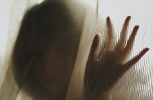 Γυναίκα πίσω από την κουρτίνα