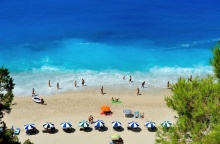 Παραλία με λουόμενους κάτω από ομπρέλες