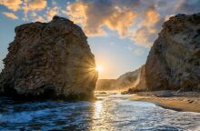 Ηλιοβασίλεμα ανάμεσα σε δύο βράχους σε παραλία της Μήλου