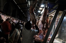 Στιγμιότυπο από κρεοπωλείο όπου εργαζόμενος ξεκρεμά αρνί από τα τσιγκέλια