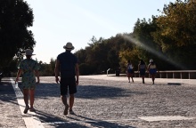 Πολίτες με καπέλο περπατούν στη Διονυσίου Αρεοπαγίτου υπό υψηλές θερμοκρασίες