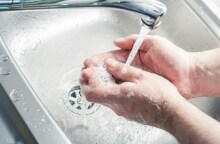 Βρύση που τρέχει νερό και άτομο που πλένει τα χέρια του