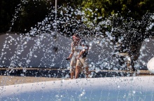 Πολίτες περπατούν πίσω από συντριβάνι