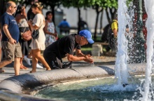 Πολίτης δροσίζεται βουτώντας τα χέρια του στο νερό του σιντριβανιού στο Σύνταγμα