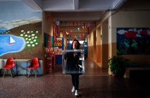 Γυναίκα με κάλπη στα χέρια σε διάδρομο σχολείου